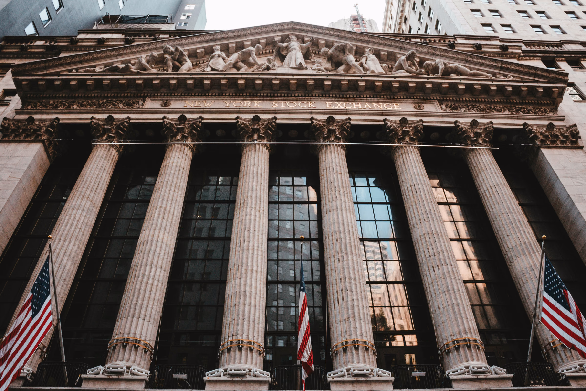 Classical columns and American flags on the New York Stock Exchange in the Financial District.