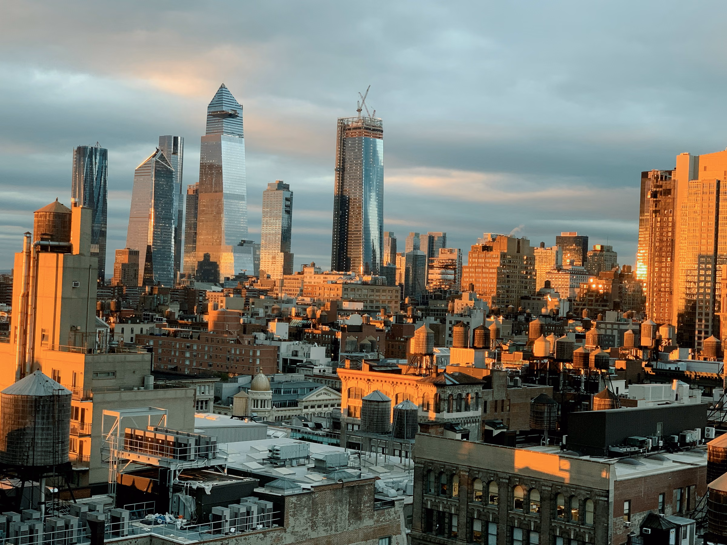 Hudson Yards towers above the surrounding Manhattan rooftops in evening light