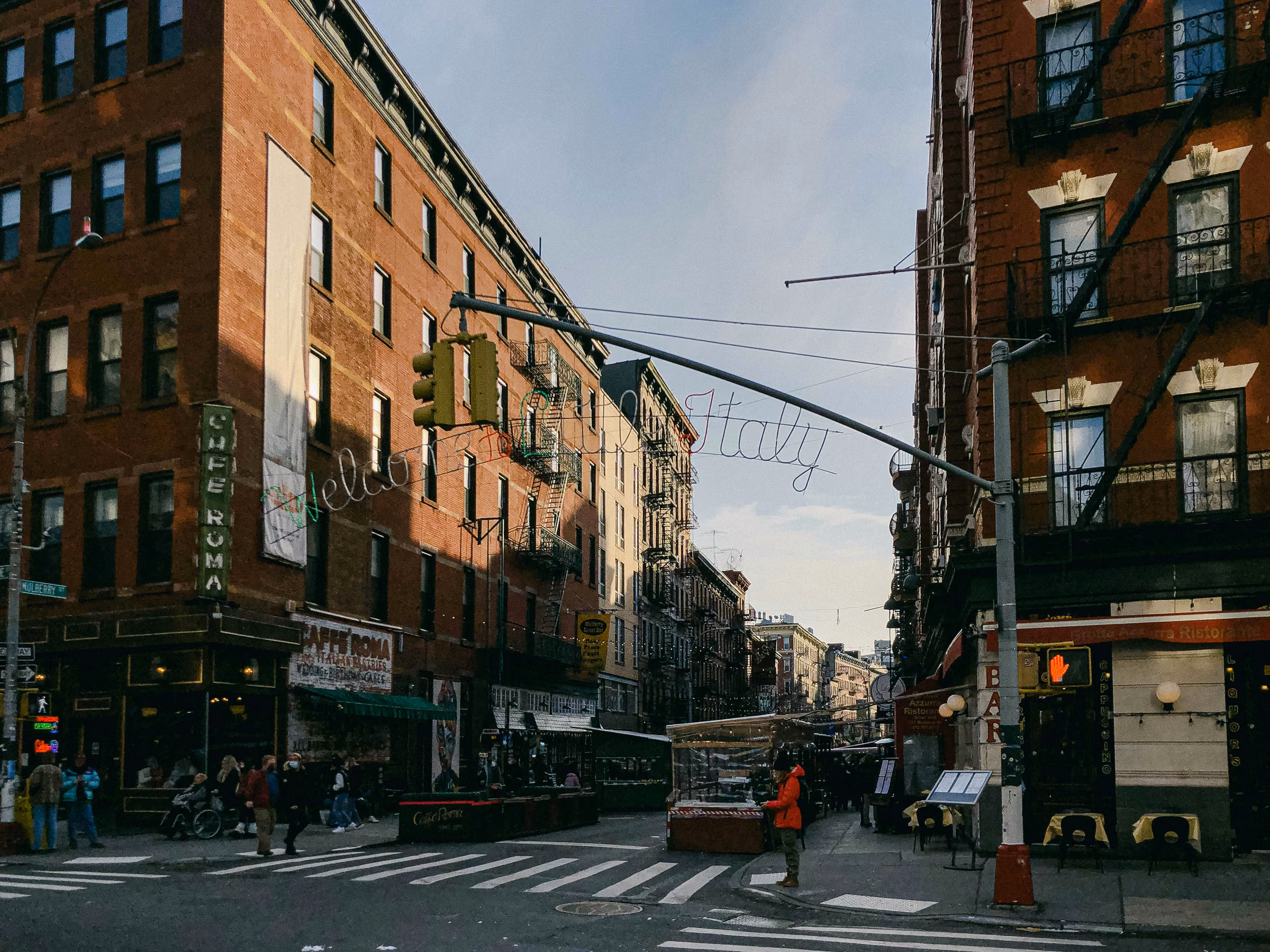 Brick buildings, street crossings, and Little Italy decorations in Manhattan.