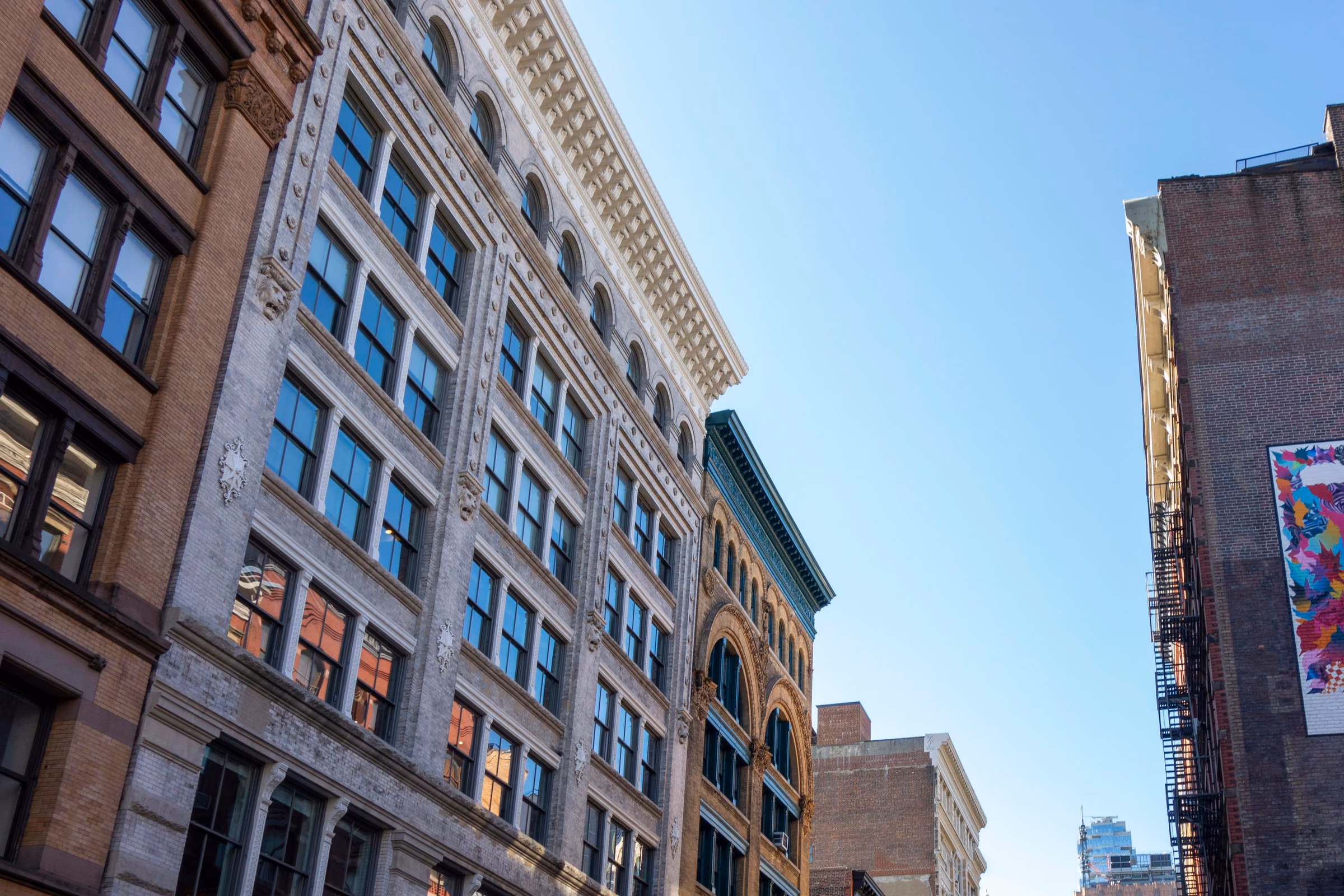 Cast-iron building facades beneath a blue sky in SoHo, Manhattan.