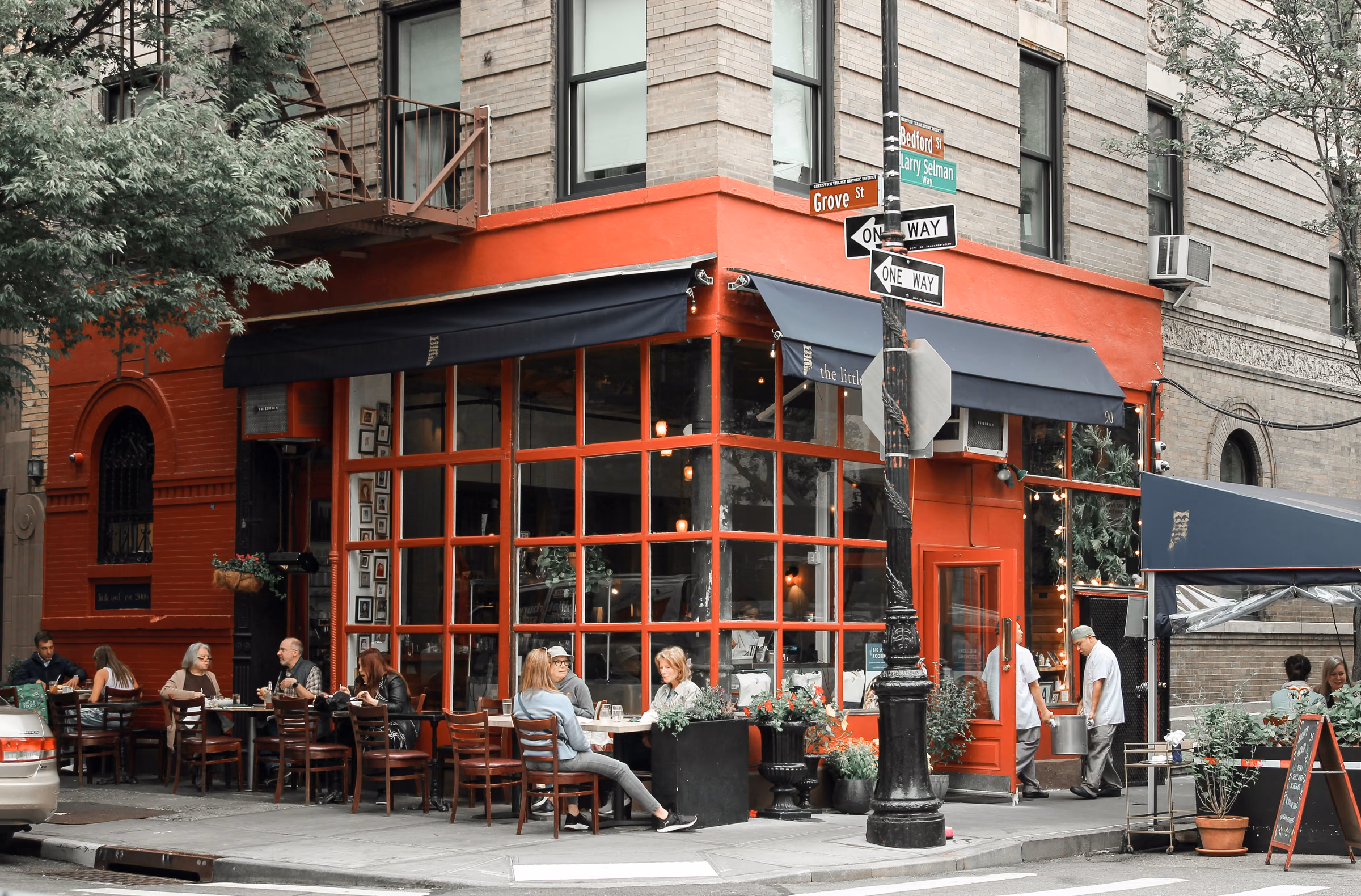 Sidewalk tables outside the red Little Owl restaurant at Bedford and Grove Streets in the West Village.