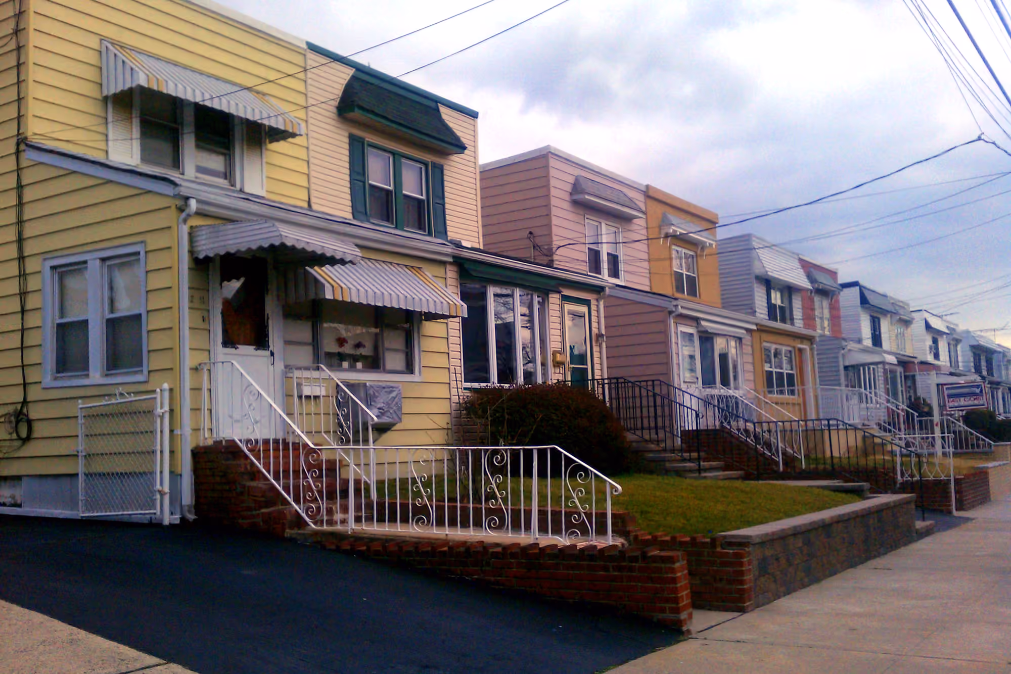 A row of attached homes with front porches in Bayside