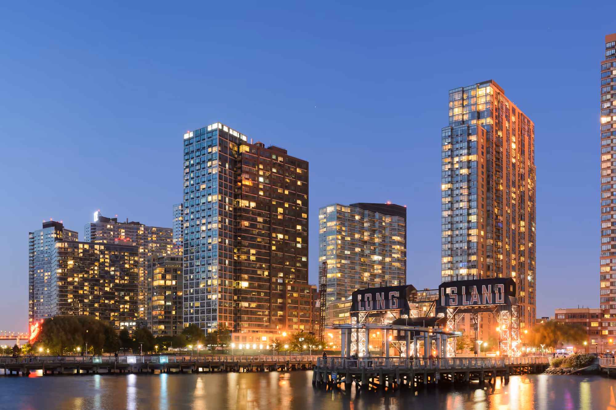 Illuminated waterfront residential towers in Long Island City at dusk