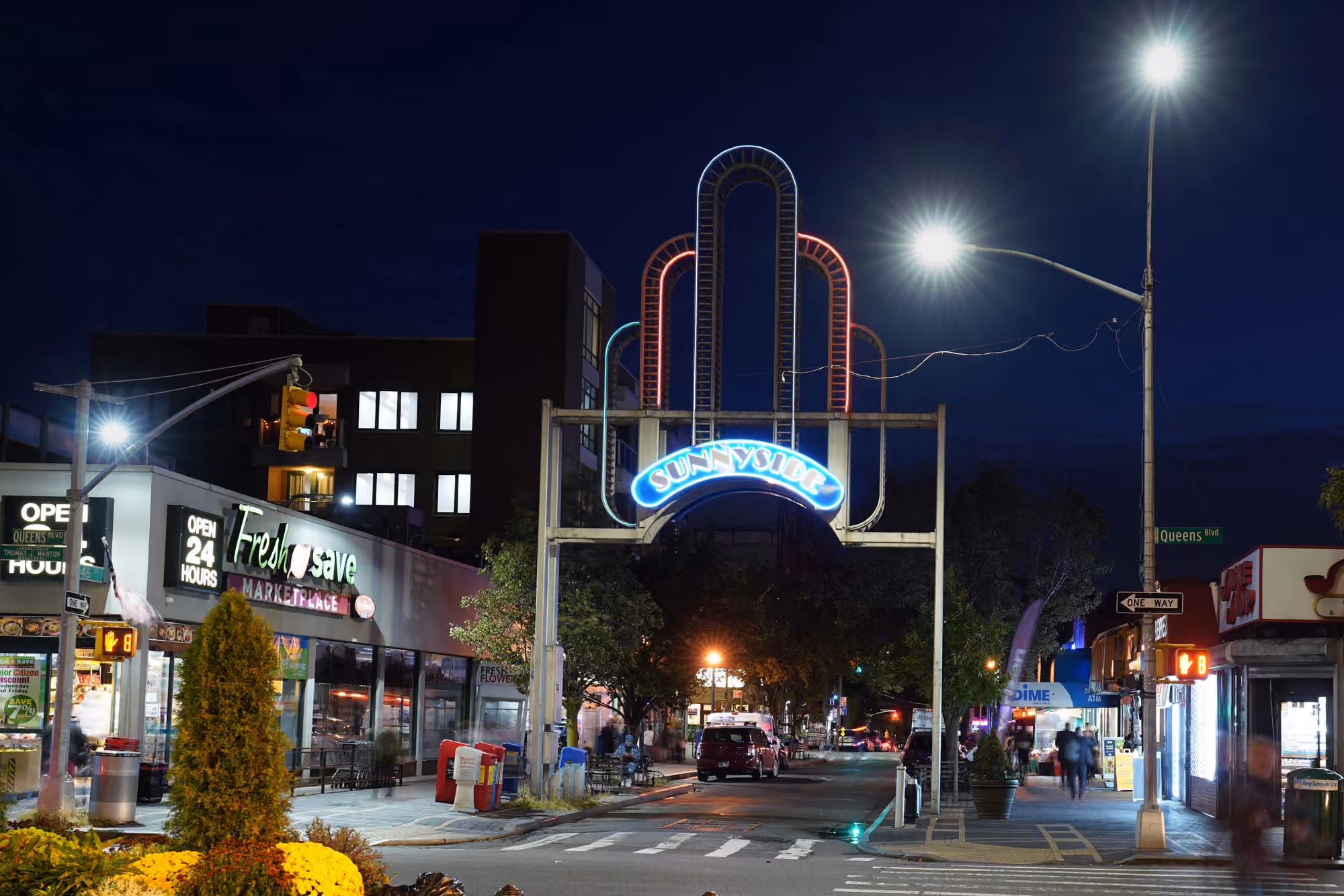 The illuminated Sunnyside arch above 46th Street at night